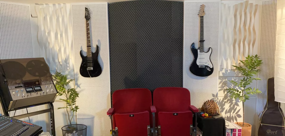 Salle d’écoute d’un studio d’enregistrement à Lucens avec guitares et traitement acoustique mural